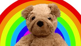 Video of teddy bear moving and dancing against rainbow background