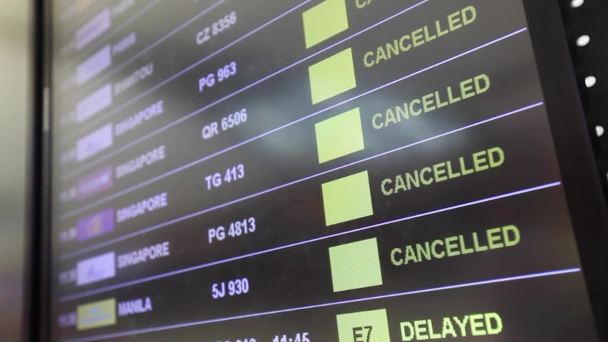 Flight cancellations in Bangkok airport on departure board screen, cancelled trip due to coronavirus COVID-19 | Shutterstock HD Video #1055300903
