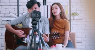 Asian young couple blogger live broadcasting while spending time together at home
