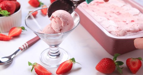 Scooping homemade strawberry ice cream. Serving healthy delicious dairy ice cream. Dolly shot 4k
