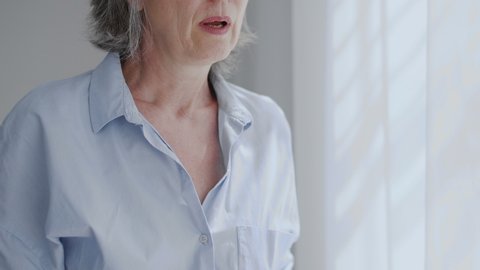 Gray-haired woman feeling pain in chest, heart attack or stroke symptoms