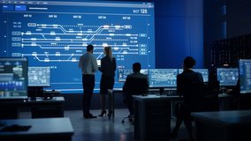 Telecommunications Company System Control and Monitoring Room with Diverse Multicultural Team of Professionals Working on Personal Computers. Big Screen Display Showing Infrastructure. Back View - Powered by Shutterstock - Get 15% off with code: PIKWIZARD15