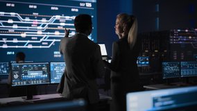 Beautiful Female Project Leader Talks with Male Team Manager works in Telecommunications System Control Room. In Background Big Screen Showing Infographics of Infrastructure, Charts, Analysis - Powered by Shutterstock - Get 15% off with code: PIKWIZARD15