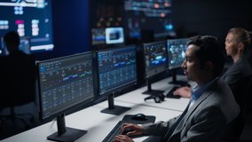 Confident Male Data Scientist Works on Personal Computer in Big Infrastructure Control Room. Stock Market Woman Specialist Uses Computer Showing Graphs, Charts, Information. Monitoring Room Team - Powered by Shutterstock - Get 15% off with code: PIKWIZARD15