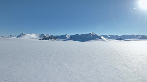 Droneflight in snow desert Antarctica showing a huge snowy glacier area, endless views and mountain range Vinson massive 