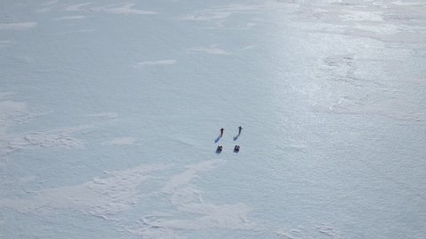 Two extreme sport athletes are hiking on a huge ice cap pulling sleds in Antarctica, South Pole