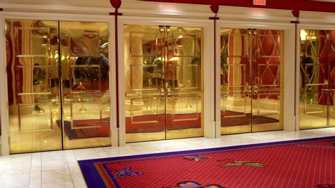 Las Vegas, Nevada / USA - June 20 2020: This panning video shows an empty luxurious gilded red carpet room with gold doors.