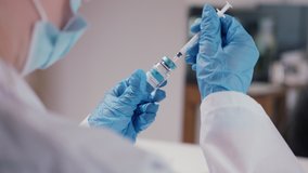 Coronavirus Vaccination Vial being used by scientist / doctor wiht injection needle - Powered by Shutterstock - Get 15% off with code: PIKWIZARD15