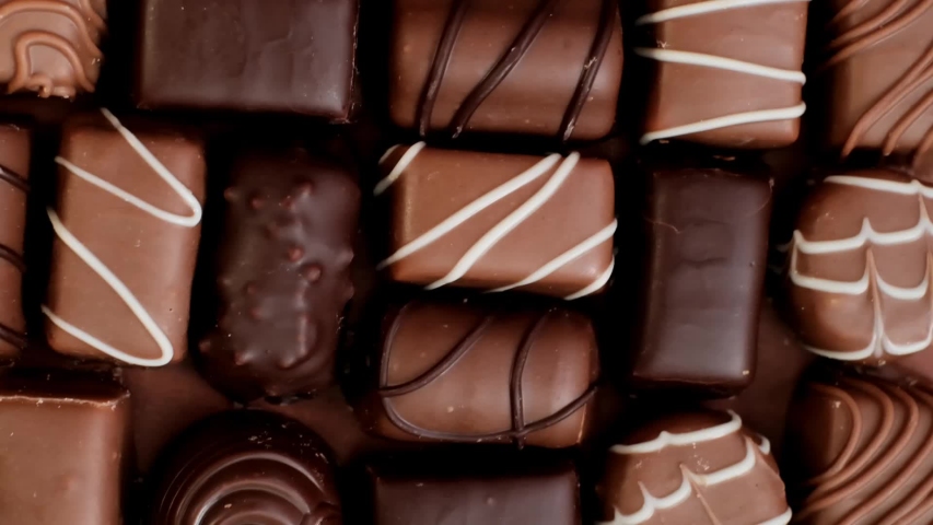 Chocolate candy set. Box of chocolates close-up .assorted chocolate sweets.Chocolate candies set in an open box. top view. sweet dessert. | Shutterstock HD Video #1055330843