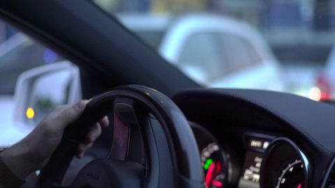 man drives a car, hands on the steering wheel closeup