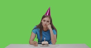 Woman eating piece of cake, alone birthday celebration. Girl having fun on green screen background, chroma key . Young female looking at camera talking make video chat, conference call, webcam view.