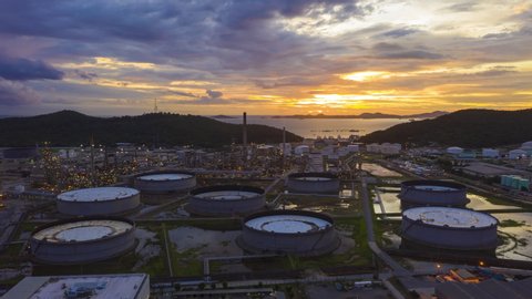 4K UHD resolution drone Hyperlapse of oil refinery plant chemical factory and power plant with many storage tanks and pipelines at sunset.