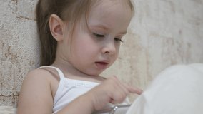 Child plays in the smartphone in the room. Distance learning of preschoolers online.