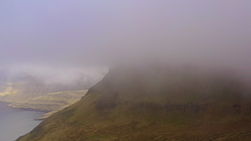 Wide Drone View Of Clouds Moving Over Mountains Of Funningur, Faroe Islands, Denmark