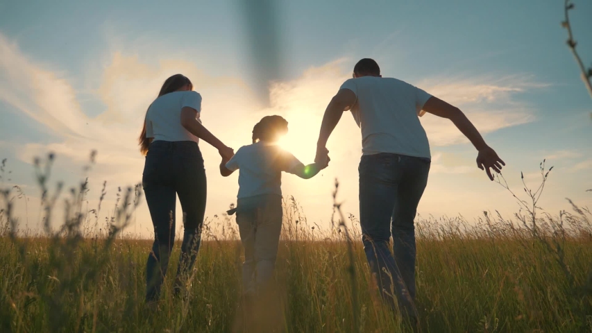 Happy family run in park at sunset. Teamwork. Parents and daughter are run at sunset. Silhouette of running happy family in park. Children are running. Silhouette of happy family in park Royalty-Free Stock Footage #1055347835