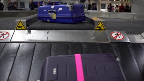 4k, Suitcase on luggage conveyor belt in the baggage claim at arrivals lounge of airport international terminal building. Luggage waiting area, journey concept-Dan