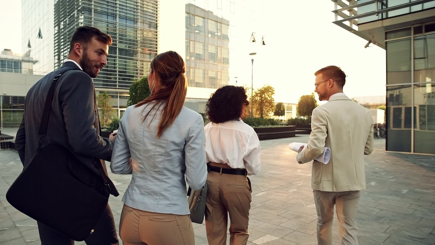 Group of business people walking outside in front of office buildings. Royalty-Free Stock Footage #1055351105