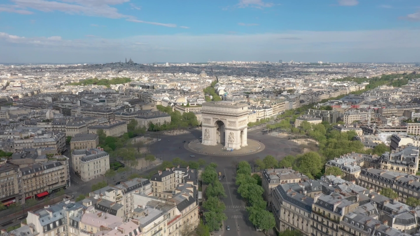 France, Paris Arc de Triomphe (Triumphal Arch) in Champs Elysees with Sacré-Coeur Basilica church in the background. Summer day. Aerial view from right to left (looks like helicopter or drone shot). Royalty-Free Stock Footage #1055357072