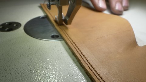 super close up. Details seam sewing machine makes a seam on a leather product.