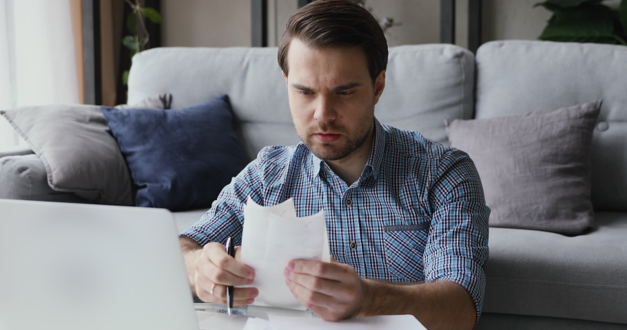 Man sitting in living room do finance analysis holds sales slip heap of receipt feels frustrated worried due lack of money, small business entrepreneur bankruptcy financial problems, overspend concept Royalty-Free Stock Footage #1055363192