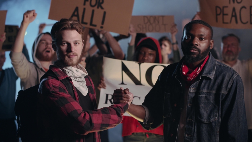 Handshake between Caucasian and Afro-american Man on Public Protest. Black Lives Matter. All People Are Equal. Human Rights and Freedom. Respect. Friendship. Royalty-Free Stock Footage #1055364962