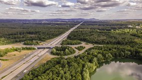 4k drone hyper lapse of the aerial view of the highway intersection of the highway 3 between Frankfurt and Darmstadt in Germany with fast moving cars at a cloudy and windy day in summer.