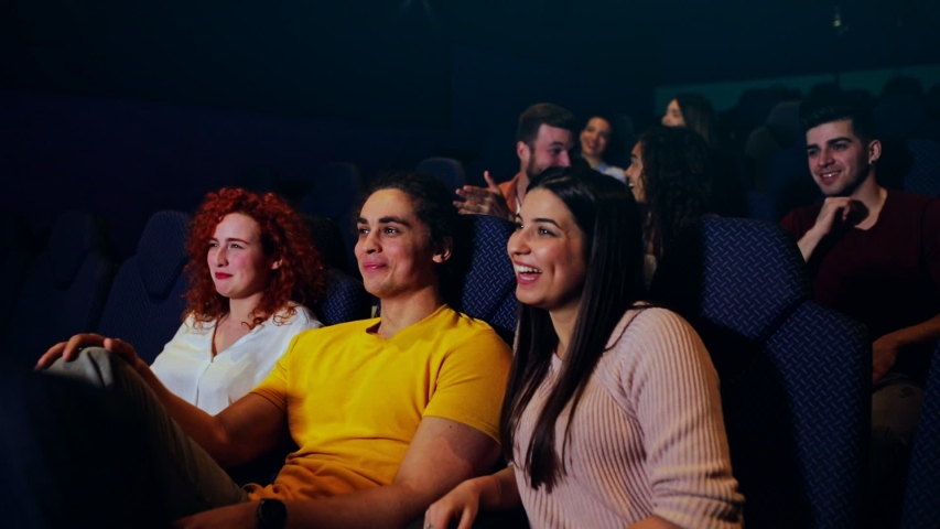 Group of cheerful people laughing while watching movie in cinema. Royalty-Free Stock Footage #1055368577
