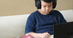 asian boy student learning online with laptop at home, education concept.