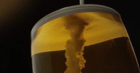 Beer Froth Pouring into a Glass with Golden Background Shot on Red Epic