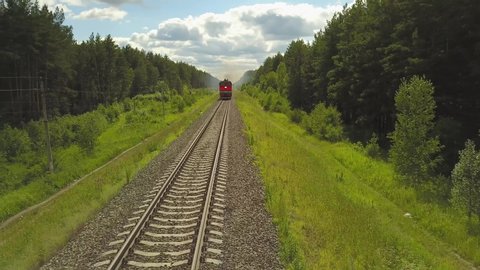 Barnaul, Altaiskiy krai / Russia - 06.28.2020 the flying camera takes pictures freight train travels through the forest to Russia