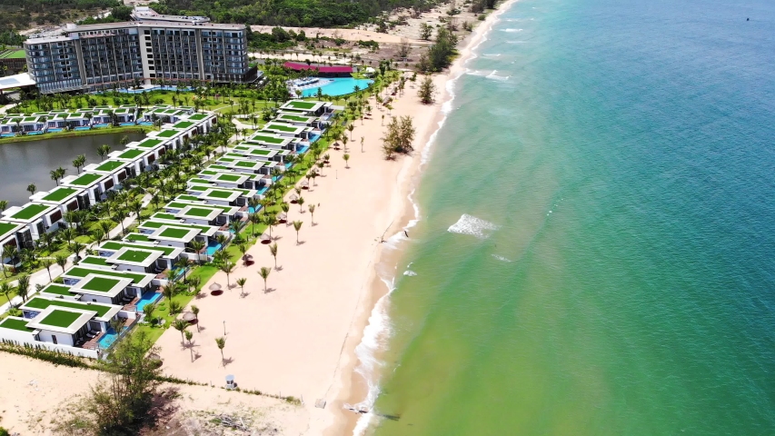 High quality royalty free stock footage, Aerial view of tropical sandy beach with palms and calm sea . Shot in Vietnam ,Phu Quoc, Romantic beach from the top video concept with beach resorts
