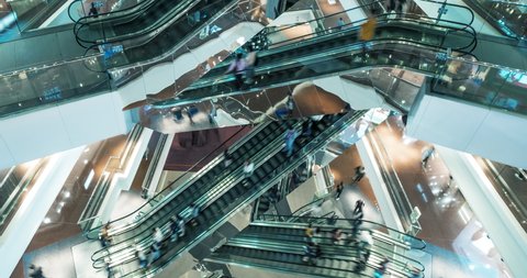 Time lapse escalators in modern shopping mall crowd of people. Very busy full of clients mall complex. Сonsumption concept.