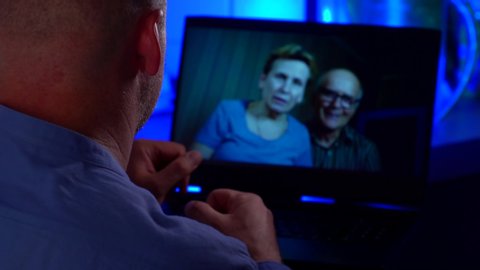 adult man is chatting with his elderly parents by video call by laptop, internet communications