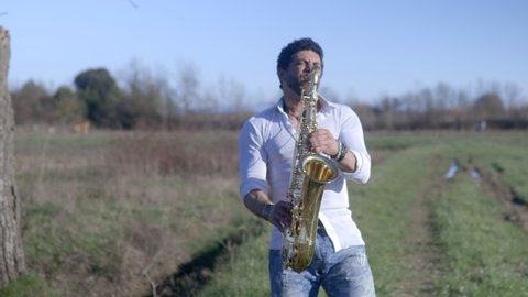 Caucasian saxophone player outdoor. Jazz and blues concept