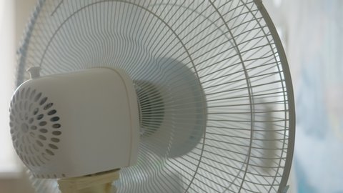 Air Fan in Apartment, Office. Closeup on Electric Fan Air at Home Across From Window in Hot Summer Day. Hot Summer Weather.