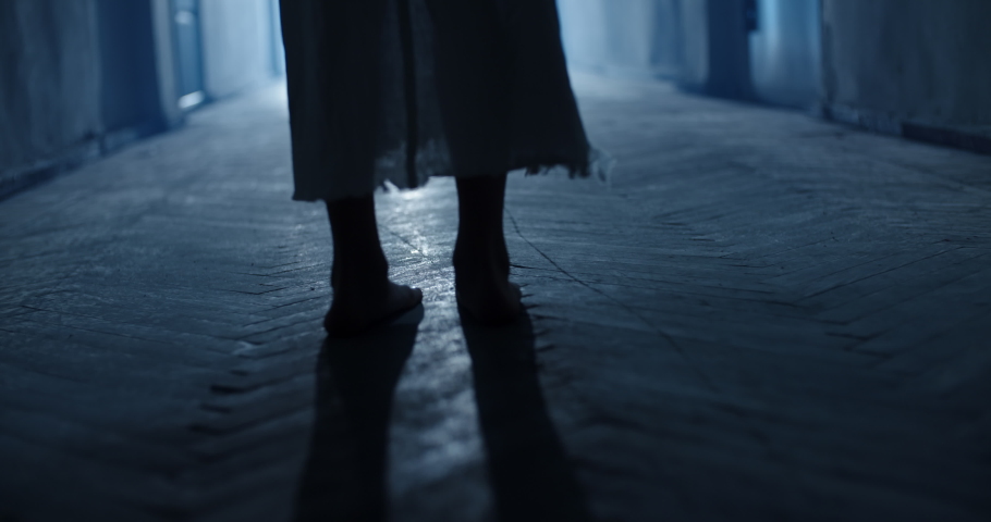 Low angle shot of legs of little girl ghost slowly creeping on floor of hallway of old abandoned haunted house - horror scene, horror movie 4k footage Royalty-Free Stock Footage #1055408567