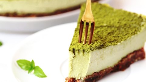 Slice of raw vegan matcha cake on white plate.