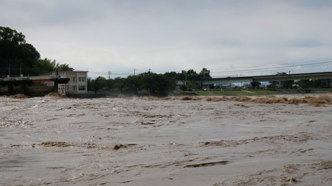 Flooding in Yatsushiro, Japan. Heavy rain caused the Kuma River to swell and dramatically flow through open floodgates. 