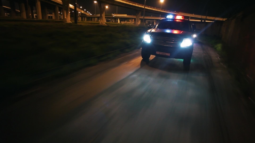 Police cars in high speed pursuit. Emergency response police patrol vehicle speeding to scene of crime at night and rain. Outdoor front view of police traffic auto driving. | Shutterstock HD Video #1055415374