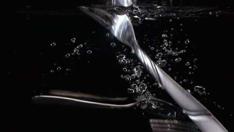 Slow Motion Cutlery Dropping in Water with Soapy Bubbles