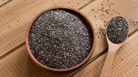 Slow motion chia seeds fall in bowl. Healthy superfood rich in Omega 3 fatty acids