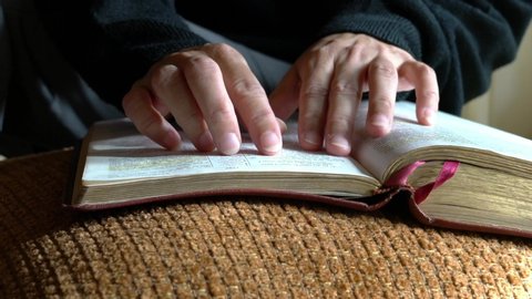 Woman reading her bible, closeup view. Fingers going line by line of the text.