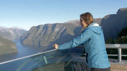 A Woman Takes in an Impressive View of Mountains and a Fjord from the Stegastein Viewing Platform in Norway, Slow Motion