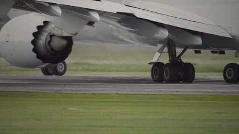 Close-up of Freighter Jet Airplane Taxiing In Airport. Chassis gear of widebody heavy airplane turning around on runway