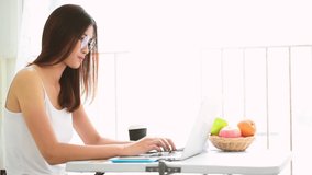Asian woman using laptop working from home on social distancing covid-19 quarantine coronavirus. Woman using laptop at home online meeting, online learning to office team conference by call conference