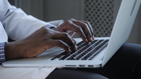 Male african american user hands typing on laptop keyboard sit at table, mixed race ethnic student professional study work with pc software technology concept, close up view