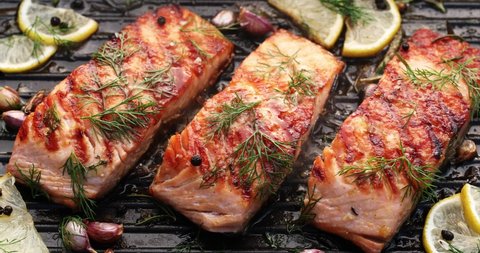 Grilled salmon fillets on a grill plate drizzled with lemon juice