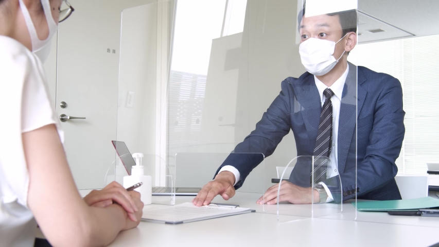 People meeting across an acrylic partitions. Infection prevention. | Shutterstock HD Video #1055444042
