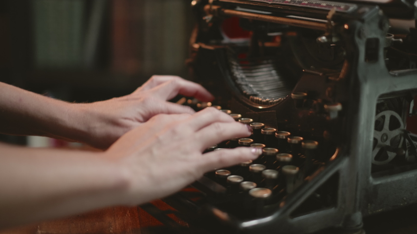 Woman typing on typewriter, slow pull out as woman types on vintage underwood typewriter. Retro typewriter keys. Attractive woman typing | Shutterstock HD Video #1055446046