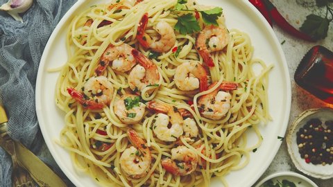 Seafood concept. Pasta with shrimps in a plate, close-up, top view, flat lay. Pasta cooking concept, ingredients and spices on a table with a dish.